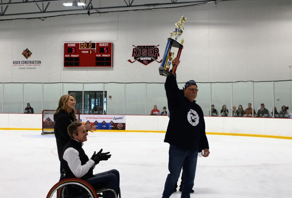 IMG_8692 elk river police chief accepting guns n hoses hockey trophy